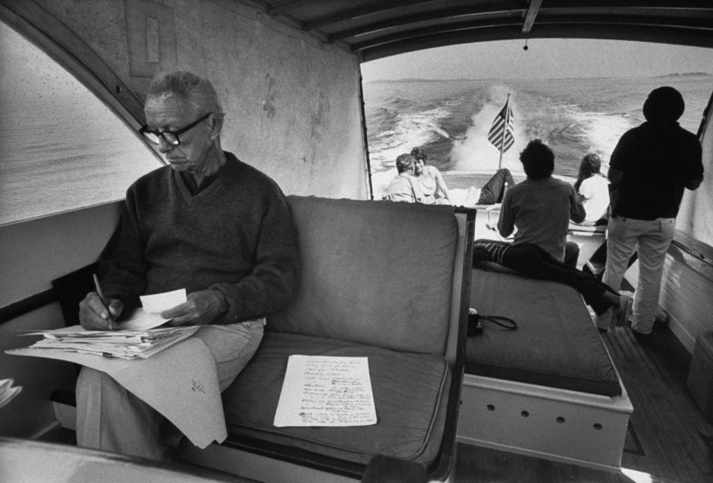 Buckminster Fuller reads mail during a grocery run to the mainland from his summer retreat on Bear Island, Maine, 1970.