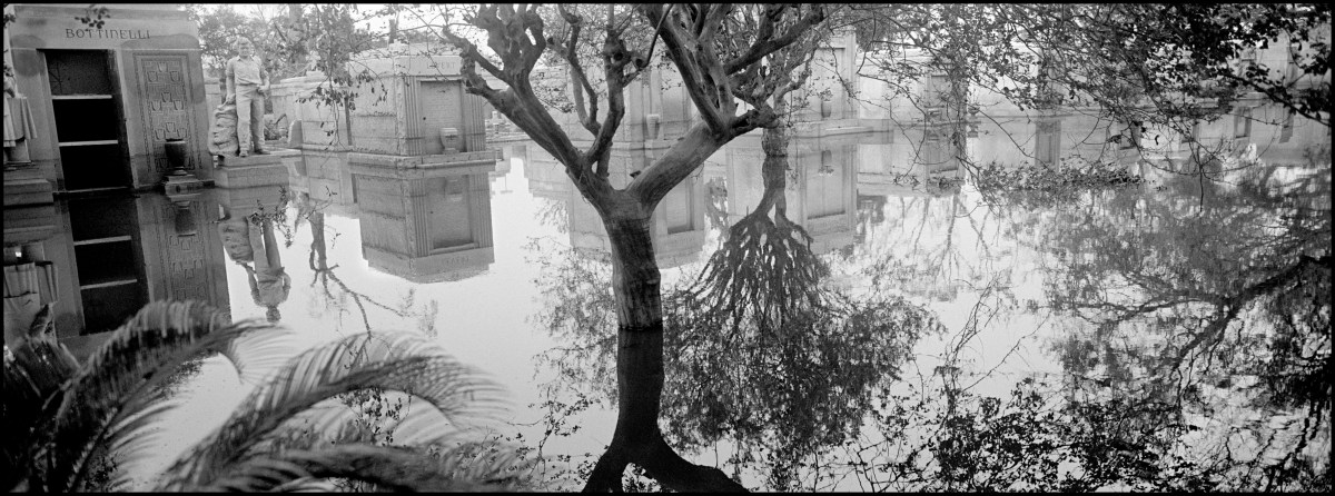 USA. New Orleans, Louisiana. September 10, 2005. Metaire Cemetery submerged. As New Orleans is below sea level, bodies are not buried but placed in mausoleums as water would force coffins to pop out of the ground if buried. Cemetery trees are reflected in the flood water.