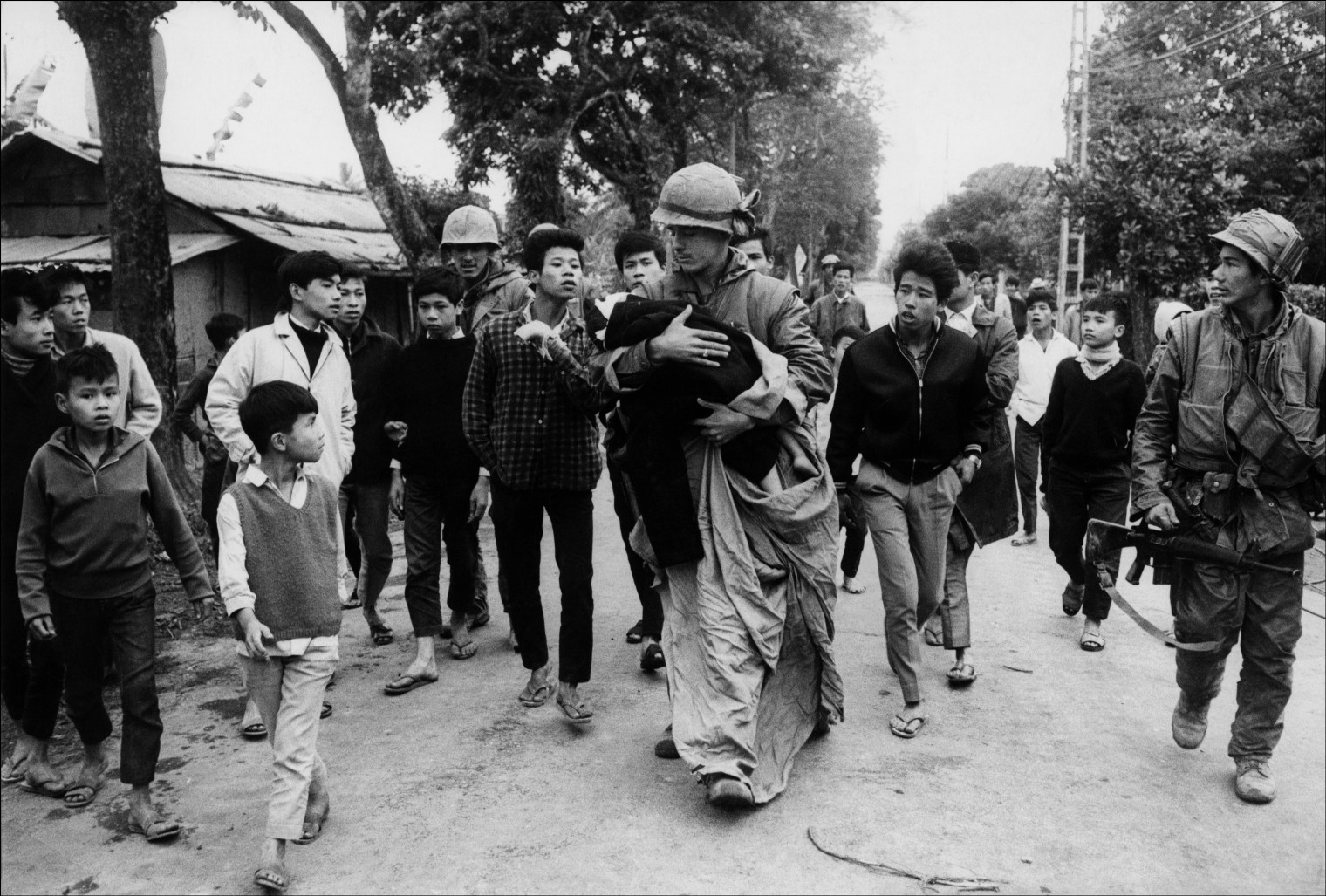 A wounded child caught in the crossfire during the Tet offensive being taken from the front by an army medic, Hue, Vietnam, 1968. 1998 Â©Â Don McCULLIN (CONTACT PRESS IMAGES)