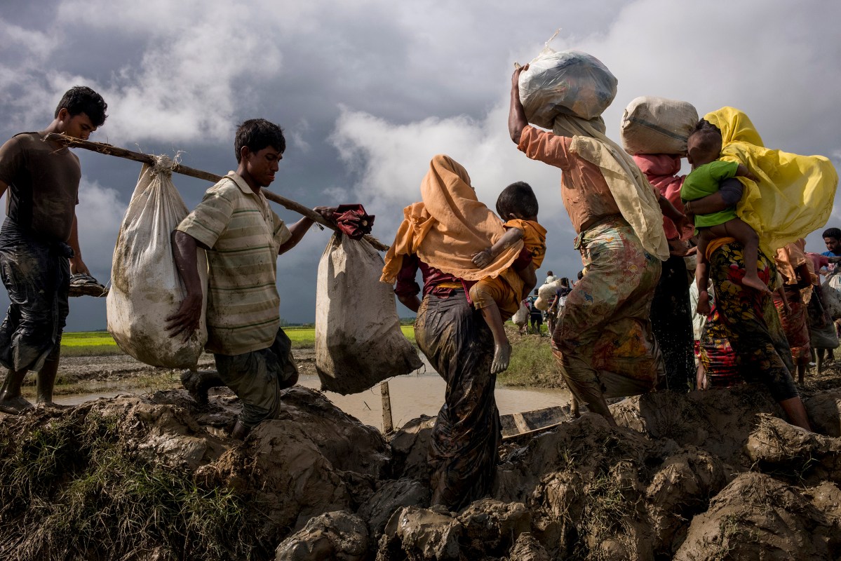 Members of Myanmar's Rohingya ethnic minority walk through paddy fields and flooded land after crossing the border into Bangladesh, August 31, 2017.