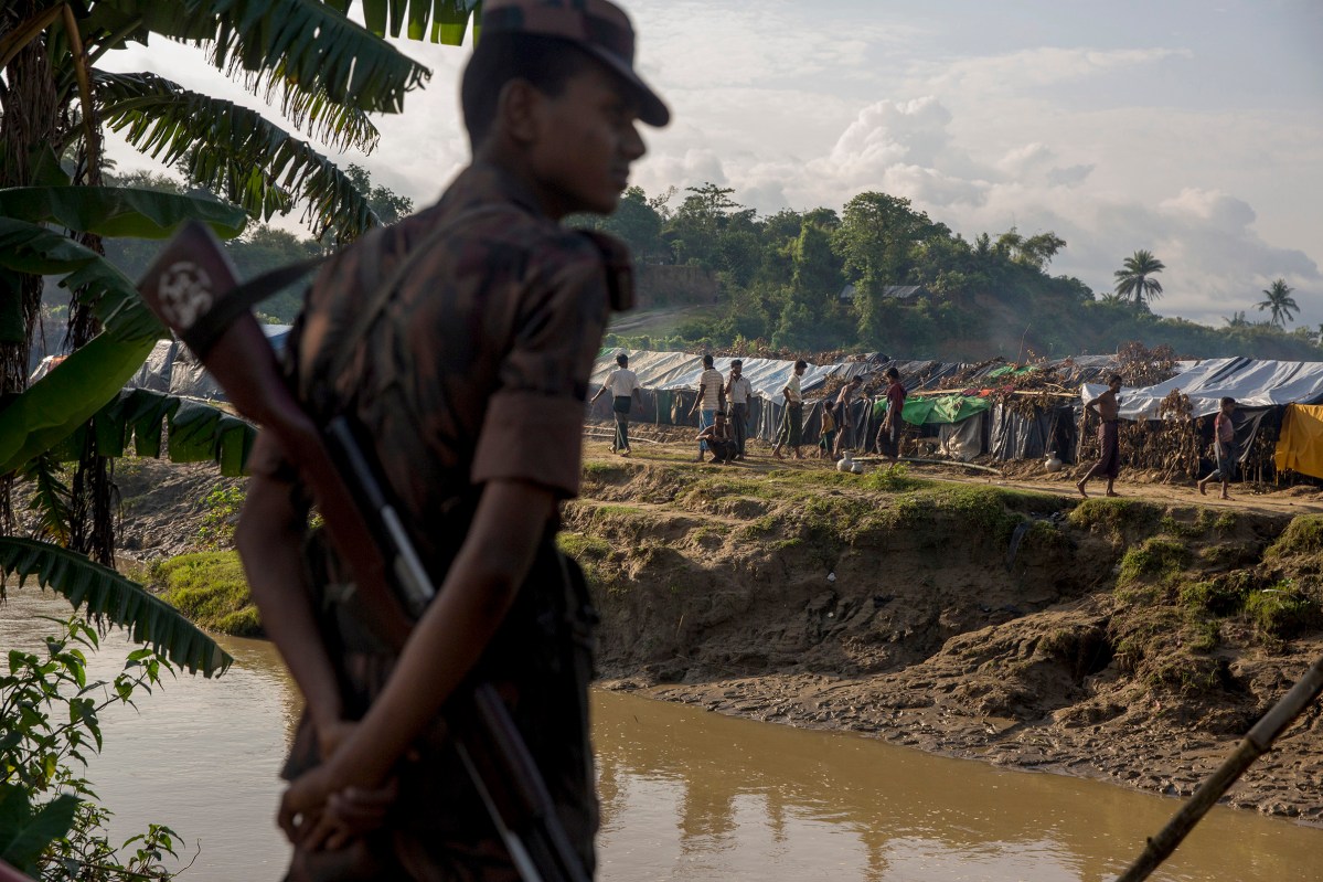 A border guard from Bangladesh maintains a group of several thousands Rohingya refugees in a no man's land inside Bangladesh territory, close to the border with Myanmar. They just allow children to cross the river to collect food and water. September 1, 2017.