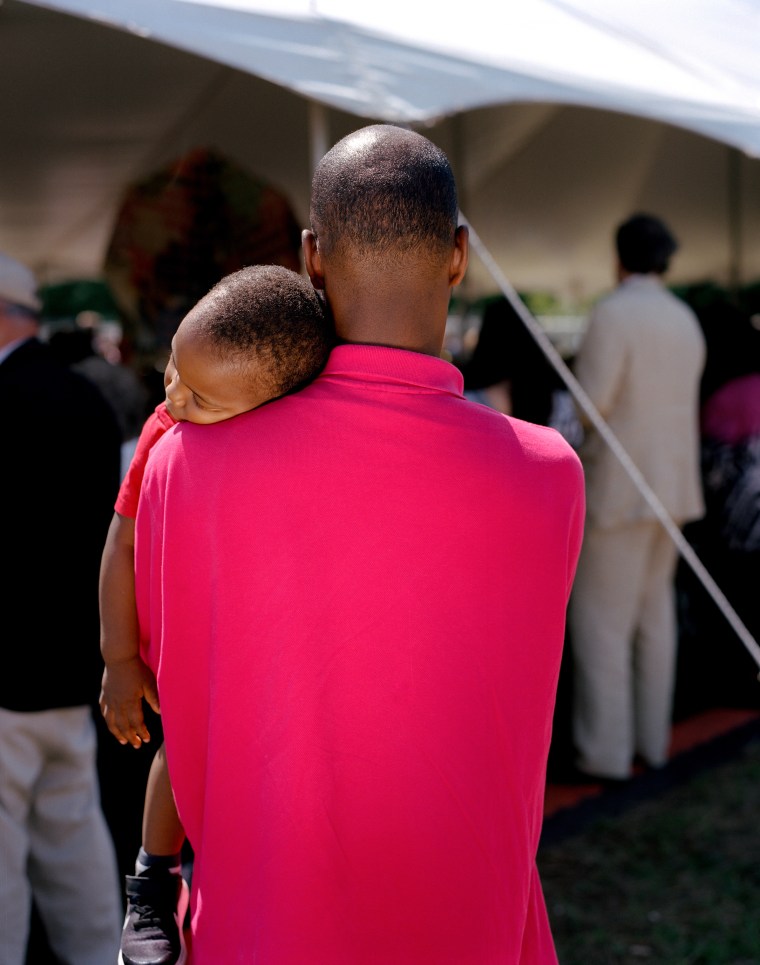 A father holds his sleeping child on May 21, 2017, during a ceremony hosted by the Lynching Sites Project of Memphis to commemorate the centennial of the Ell Persons mass spectacle lynching, considered among the most brutal in American history. At the time, the killing was described as a carnival. In 2017, more than 500 people came out to pray and mourn together.