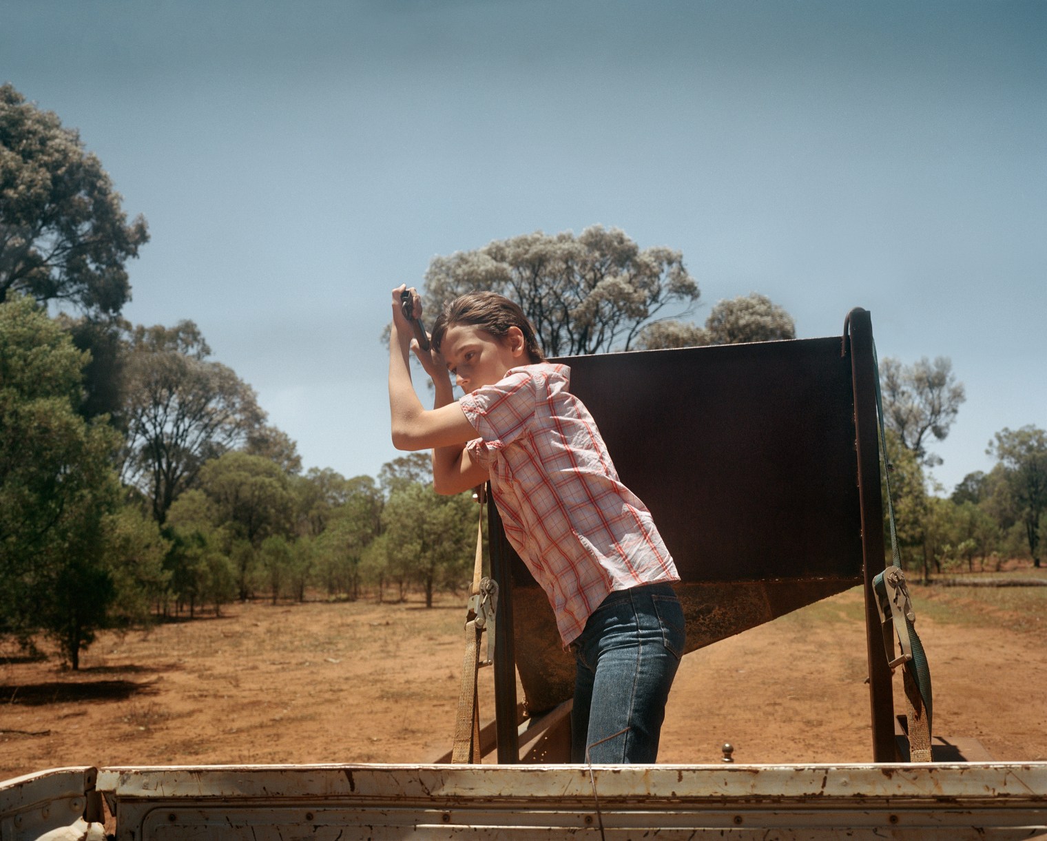 Nicholas Clark, 12, releases feed for sheep on Kandimulla Property in Queensland in November. Without an ability to grow food naturally, Kandimulla owner Kent Morris is forced to buy food to feed his livestock.