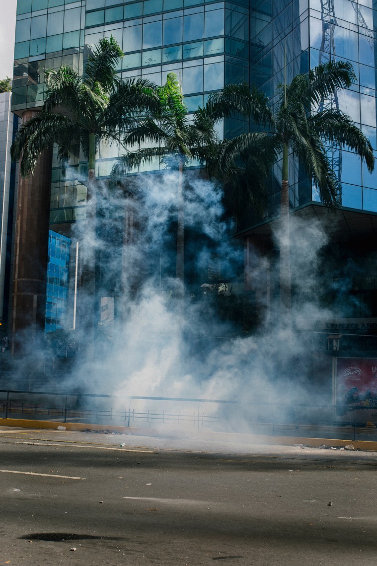 Tear gas floats over the pavement during a protest in El Rosal in Caracas, Venezuela, on January 23, 2019.