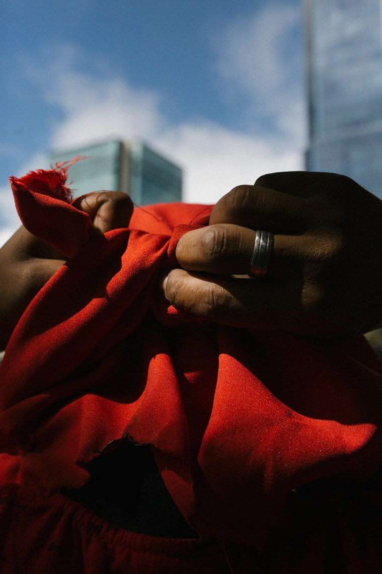 A man ties a piece of fabric to cover his face during a protest.