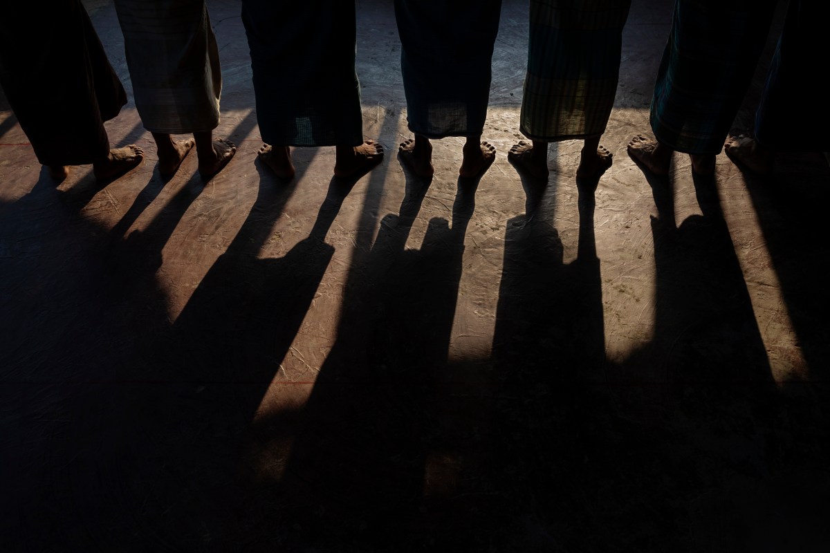 Men stand during afternoon prayers at a mosque.