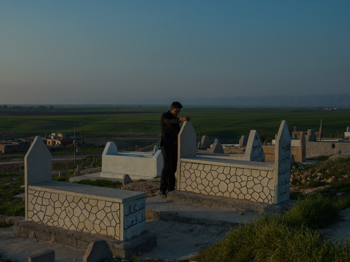 A man mourns at a Yezidi cemetery in Duhok, where many Yezidis killed by ISIS are buried, in February.