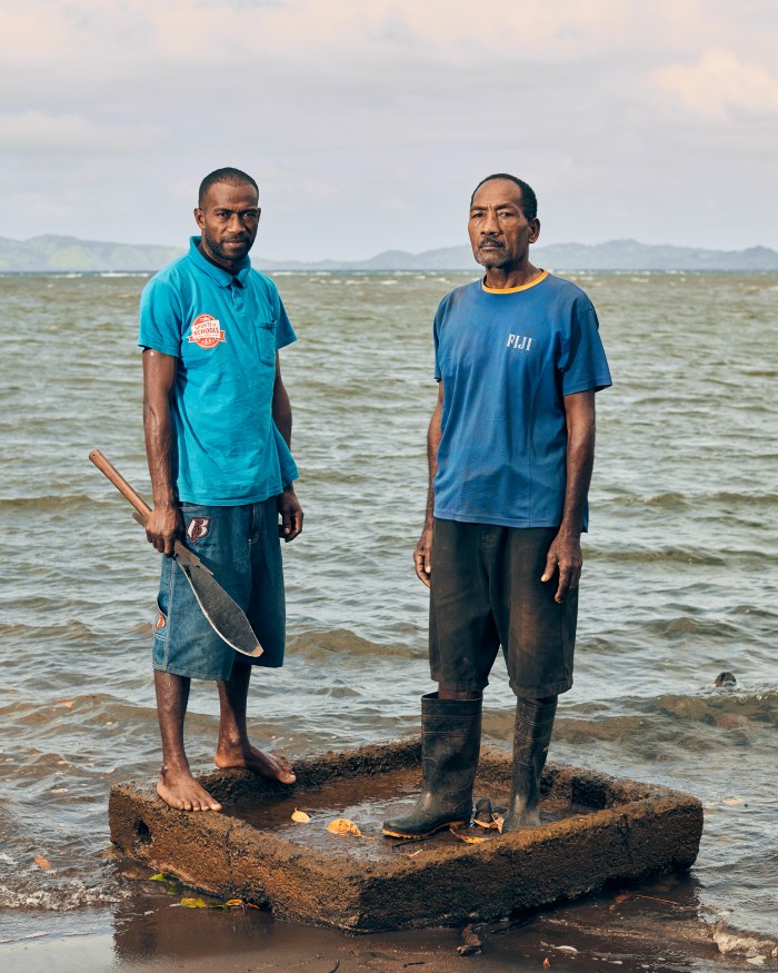 Vunidogoloa administrator Sailosi Ramatu, right, and his son Simi Botu stand on what remains of their former home.