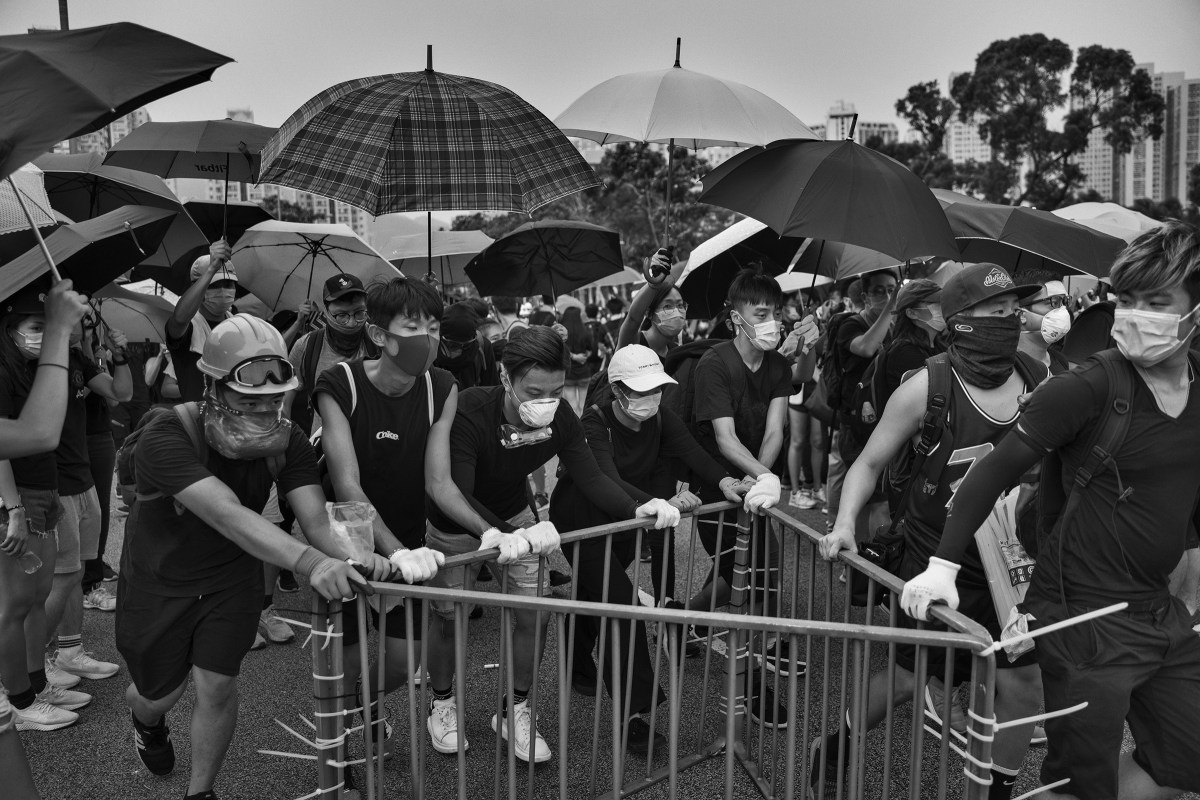 Antigovernment protesters block a road near the Tai Po police station on Aug. 10.