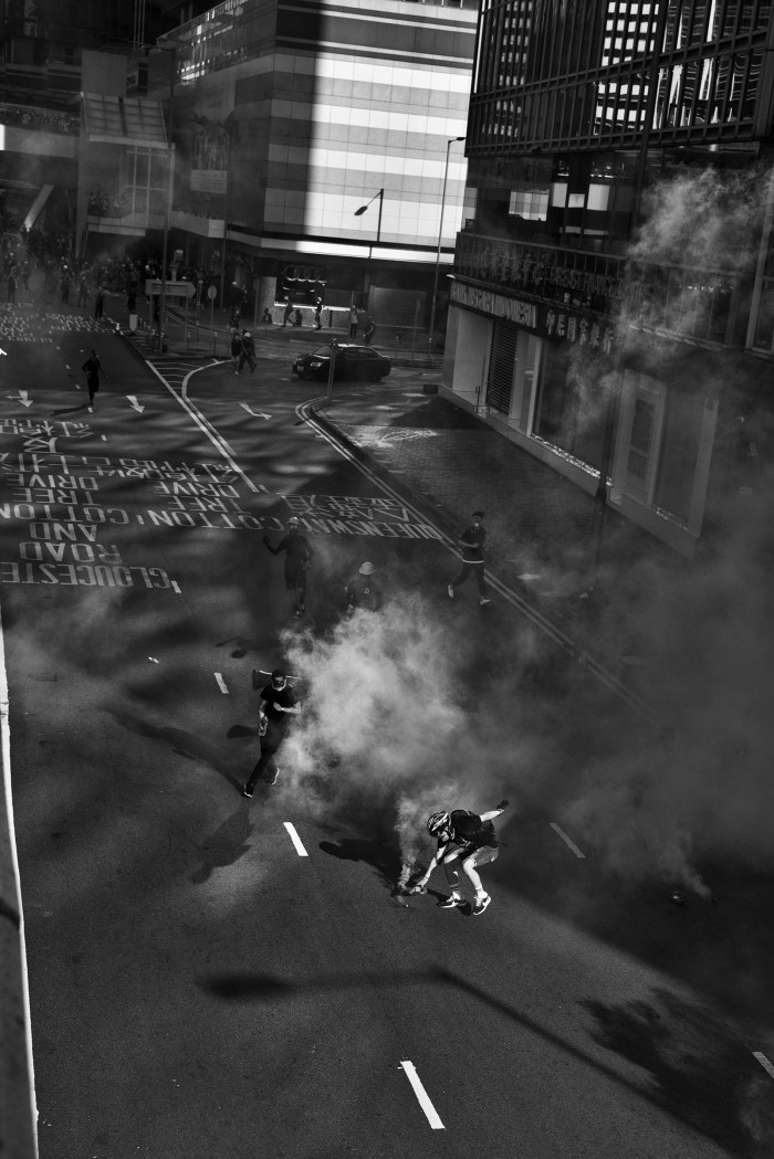 Antigovernment protesters grab tear-gas canisters fired by police during a protest near the Legislative Council in Hong Kong on Aug. 5.