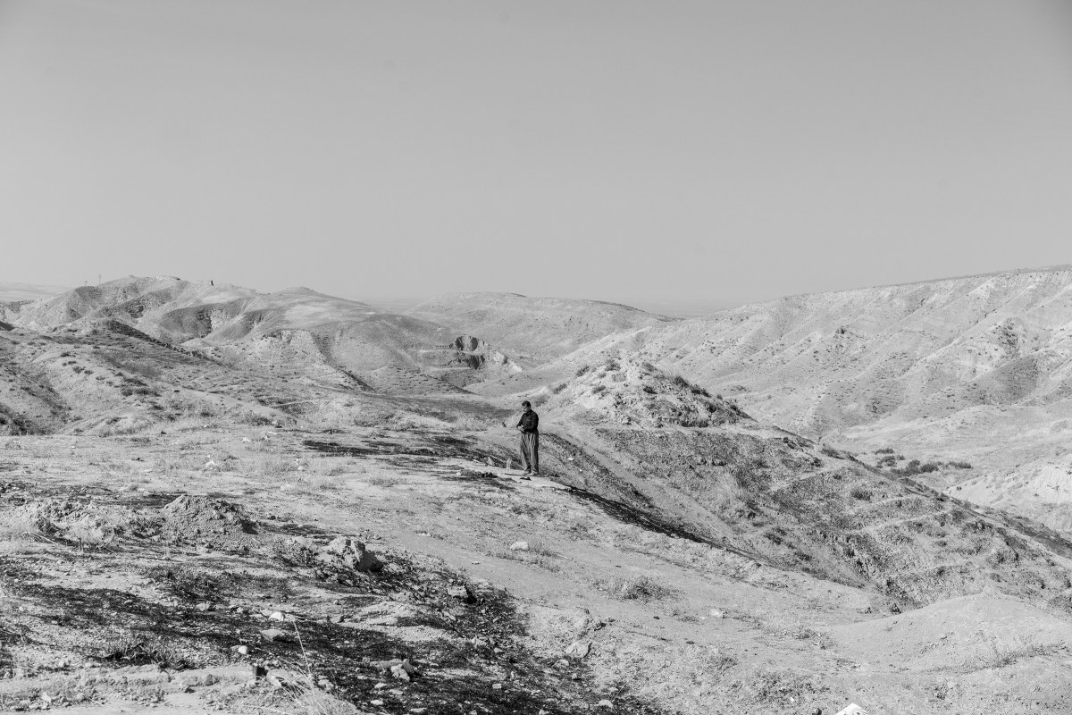 A Kurdish man prays on a hill near the Bardarash camp on Oct. 31.